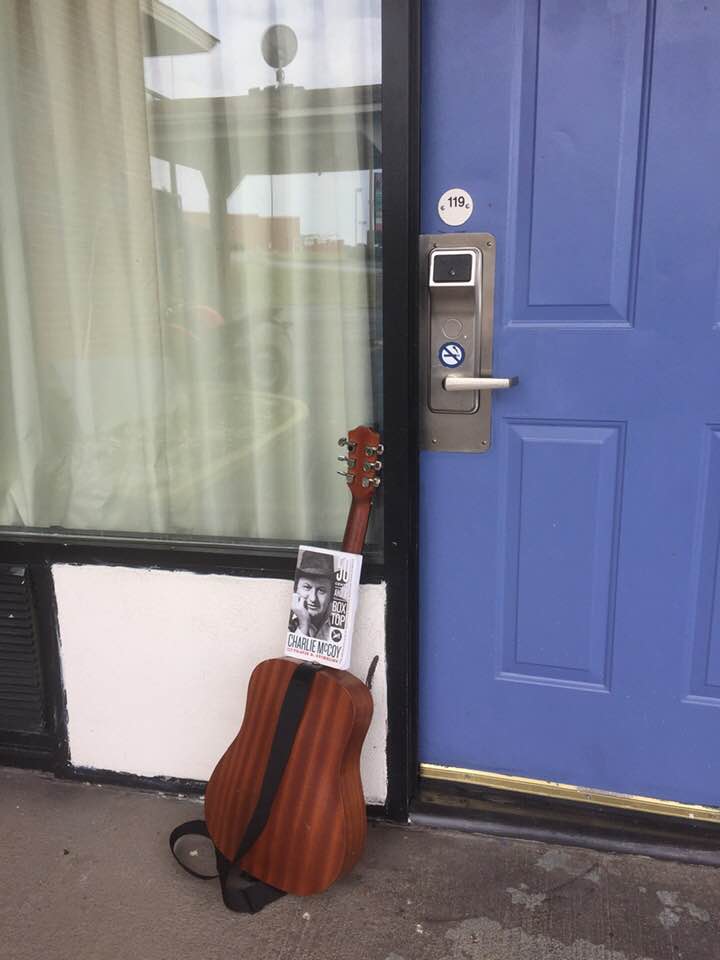 guitar leaning against hotel room door